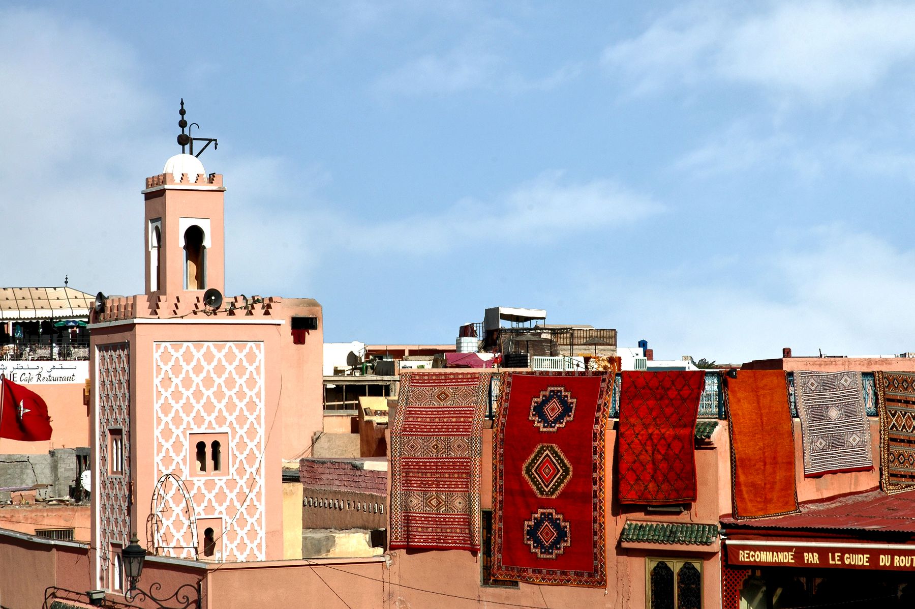 Toit-terrasse à Marrakech avec tapis marocains traditionnels et architecture de la médina